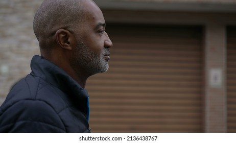 An Introspective African Man Walking Outside In Street A Contemplative Black Person