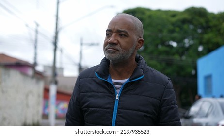 An Introspective African Man Walking Outside In Street A Contemplative Black Person