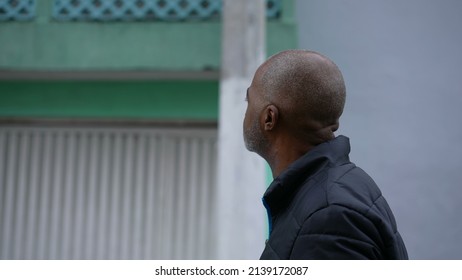 An Introspective African Man Walking Outside In Street A Contemplative Black Person