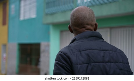 An Introspective African Man Walking Outside In Street A Contemplative Black Person