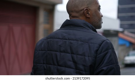 An Introspective African Man Walking Outside In Street A Contemplative Black Person