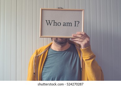 Introspective man  - Who am I, self-knowledge concept with question covering adult male face. - Powered by Shutterstock