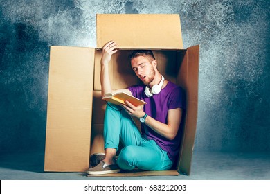 Introvert Concept. Man Sitting Inside Box And Reading Book