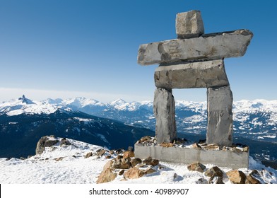 Inukshuk at the top of Whistler Mountain, site of 2010 Winter Olympics, with the Black Tusk peak in the background mountain range; in British Columbia, Canada