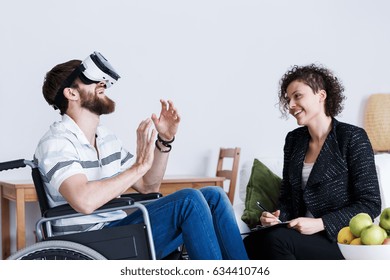 Invalid man in wheelchair using indoor virtual reality device  - Powered by Shutterstock