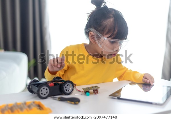 Inventive kid\
constructing robot cars at\
home