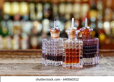 Inventory Of The Bartender At The Bar Counter - Droppers For Bitters And Syrups Stand In A Row On A Blurred Background Of The Bar