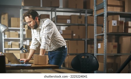 Inventory Manager Preparing a Small Cardboard Parcel for Postage. Stylish Young Male Small Business Owner Working on Laptop Computer in Warehouse Facility - Powered by Shutterstock