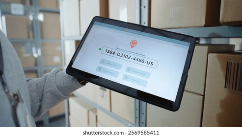 Inventory Manager Scans Code on Cardboard Box with Barcode Scanner, Checks Parcel Information. Tablet Computer Screen Shows Delivery Tracking System for Monitoring Package with Online Orders. Close Up