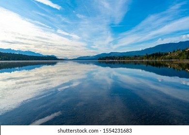 Invermere, British Columbia, Canada - Reflection of mountains and blue sky in Windermere Lake.