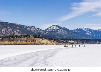 INVERMERE, CANADA - MARCH 17, 2020: life on frozen Windermere lake and rocky mountains in british columbia canada.