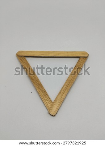 Inverted equilateral triangle shape made from natural wooden slats isolated on white background. Minimalist geometric frame.