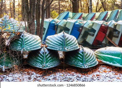 Inverted Walking Boats For Wintering In The Park. Winter Boat Storage. Stacked Up Rowboats Of A Boat Hire In Winter