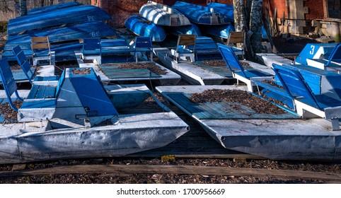 Inverted Walking Boats For Wintering In The Park. Winter Boat Storage. Stacked Up Rowboats Of A Boat Hire In Winter