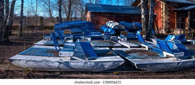 Inverted Walking Boats For Wintering In The Park. Winter Boat Storage. Stacked Up Rowboats Of A Boat Hire In Winter