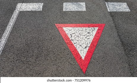 Inverted white with red border triangular road sign yield that you need to wait and give other cars the right to pass