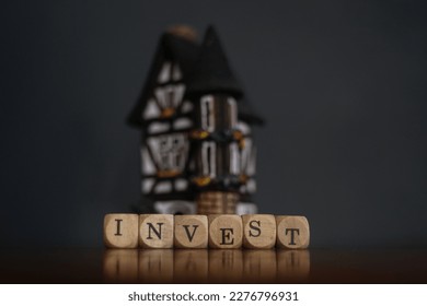 Invest Concept. Word invest on wood cubes and miniature house  - Shutterstock ID 2276796931