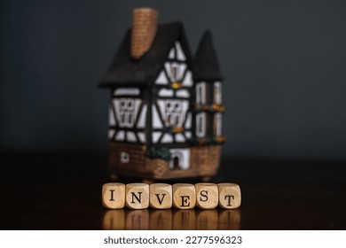 Invest Concept. Word invest on wood cubes and miniature house  - Shutterstock ID 2277596323