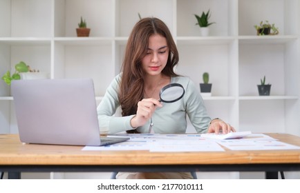 Investigator or auditor checking financial documents with magnifying glass over office desk. - Powered by Shutterstock