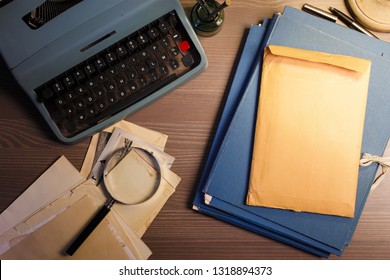 Investigator desk with confidential documents, magnifying glass, vintage typewriter. Secret documents investigation concept. 