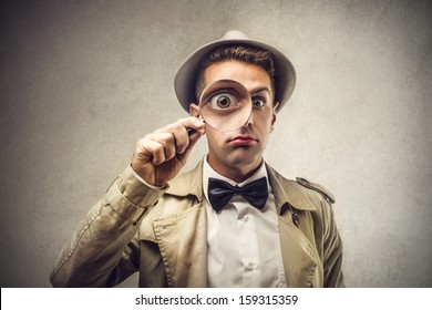 investigator looking with magnifying glass - Shutterstock ID 159315359
