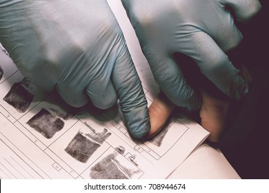 The investigator takes fingerprints from the suspect in the crime. Investigation is a crime. Crime. - Shutterstock ID 708944674