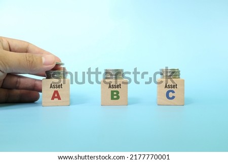 Investing asset allocation and diversification concept. Human hand stacking coins on multiple blocks.