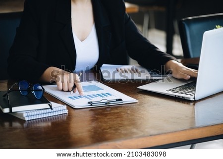 Investment concepts, businesswomen use document and computers to analyze stock markets, quantitative data collection, financial statement analysis, profitability through internet technology.