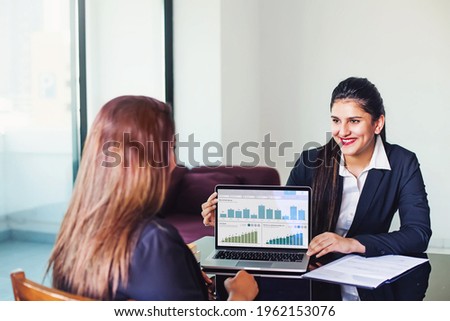 Investment consultant - Indian woman in formal suit, showing fund performance report with graphs on the laptop screen