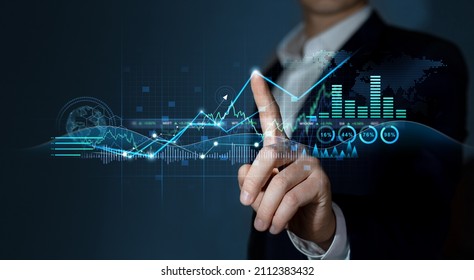  Investment of growth on currency rate. Businessman draws growing virtual hologram of statistics, graph and chart. Business strategy development and growing growth plan. - Shutterstock ID 2112383432