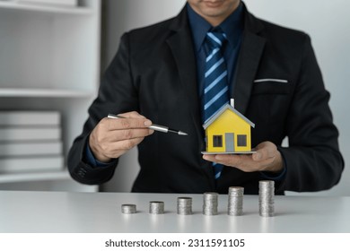 Investment, home design, Save Money For House, businessman, ideas for saving money, buying a house or borrowing money, real estate investment planning and money saving ideas financial planning. - Shutterstock ID 2311591105
