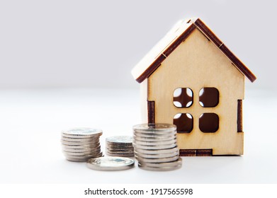 Investment real estate concept. Mortgage concept for money house made of coins. House Model Money White Background Savings Plans Housing Finance Banking. wooden house model on pile of Euro banknote