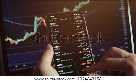 investment stockbroker stock market analysis data graph with price rates. Stock market trader analyzing bitcoin price trend. Investment broker trading bitcoin crypto currency using phone and laptop. 