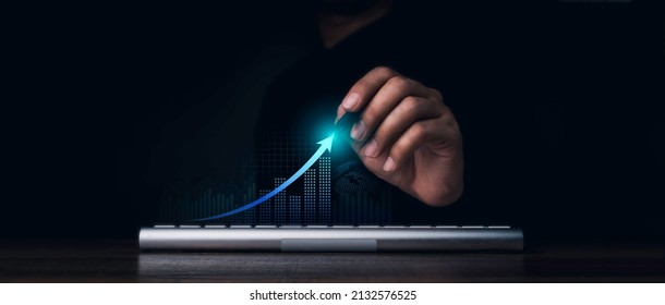 Investment technology, financial, return on investment - ROI concepts. Increasing arrow, the exponential curve of progress in business performance over charts draws by pen in hand on dark background.
