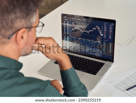 Investor trader analyzing financial trading crypto stock market checking balance digital data doing investing analysis looking at computer screen thinking of inflation drop risk. Over shoulder view.