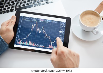 Investor Watching The Change Of Stock Market On Tablet.