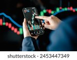 Investors analyze the data stock market index via smartphone screen to trade the stock chart for planning investments take profit, trade stock exchange market and cryptocurrency data, financial.