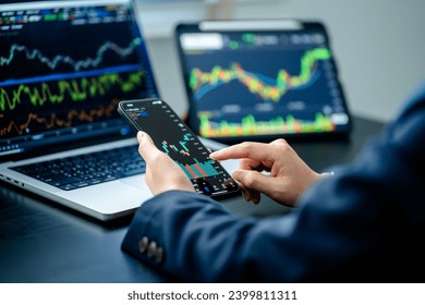 Investors analyze the data stock market index via smartphone screen to trade the stock chart for planning investments take profit, trade stock exchange market and cryptocurrency data, financial. - Powered by Shutterstock