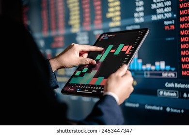 Investors analyze the data stock market index via digital tablet screen to trade the stock chart for planning investments take profit, trade stock exchange market and cryptocurrency data, financial. - Powered by Shutterstock