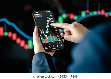 Investors analyze the data stock market index via smartphone screen to trade the stock chart for planning investments take profit, trade stock exchange market and cryptocurrency data, financial. - Powered by Shutterstock