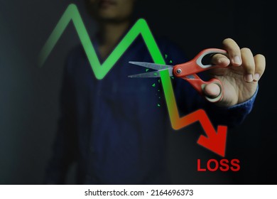 Investors decide to use scissors to cut or eliminate the loss portion of the red chart to maintain costs or prevent further losses in the stock market. cut loss concept. - Shutterstock ID 2164696373