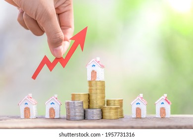 The investor's hand catches the red arrow.Business investment ideas.Concept of real estate investment.Business growth.House on a pile of coins.Stack of coins arranged in ascending order. - Shutterstock ID 1957731316