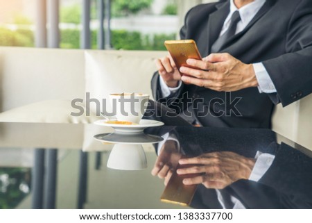 Investors, real estate businesses, wearing suits, reading information from mobile phones, online learning, communicating Drink coffee in the morning to plan a business at the club house.