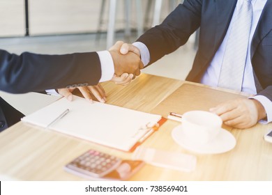 Investors Reassure Businessman Or Foreign Partners In Real Estate Investment New Project. Lawyers Join Hands With Clients To Agree On The Job With Confidence While Checking Documents At Coffee Shop.