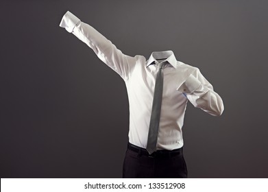 invisible man in formal wear standing like super man against grey background
