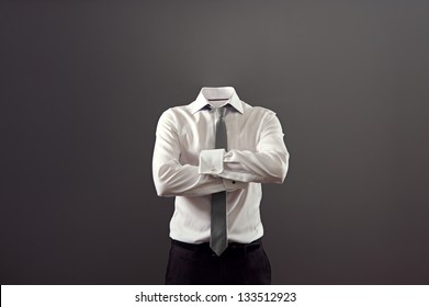 invisible man standing with folded arms over his chest against grey background