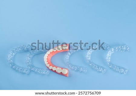 Invisible and removable aligners for teeth alignment on a blue background