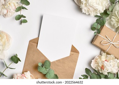 Invitation Or Greeting Card Mockup With Envelope, Gift Box And White Peony Flowers And Eucalyptus Twigs