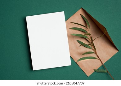 Invitation Or Greeting Card Mockup With Envelope And Natural Eucalyptus Twigs On Green Paper Background