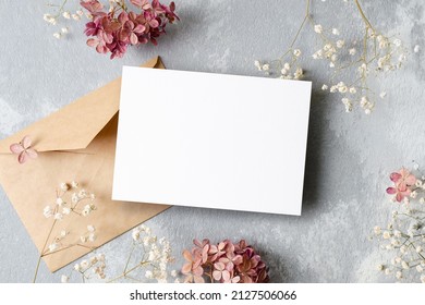 Invitation or greeting card mockup with envelope and flowers decorations. Blank card mockup on grey background. - Shutterstock ID 2127506066